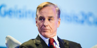 Howard Dean sits during a conference