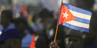 Image: A person waves a Cuban flag