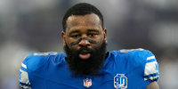 Isaiah Buggs stands on the field before an NFL football game between the Detroit Lions and the Minnesota Vikings, in Minneapolis