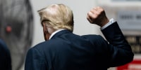 Former President Donald Trump raises his fist as he leaves the courtroom