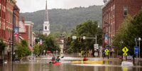 People in canoes on a flooded street