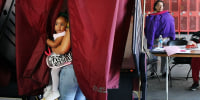 A voter holds her daughter in a voting booth