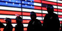 New York  Police Department officers with helmets stand in front of a building with the American flag in Times Square.