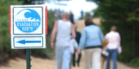 Residents walk toward the designated safe area in a tsunami drill, in Samoa, Calif.