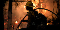  A firefighter with the U.S. Forest Service protects the Strawberry General Store on Highway 50 in El Dorado County after a backfire was set.