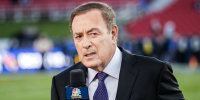 Al Michaels speaks into an NBC Sports microphone on the football field