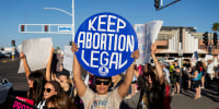 A protester holds a sign that reads "Keep Abortion Legal"