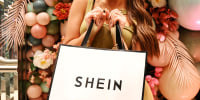 A woman holds a Shein shopping bag 