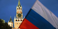 The Russian flag in front of the Kremlin's Spasskaya Tower.