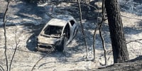 A completely burned car in a park