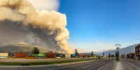 Smoke can be seen in the distance on a street outside