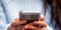 A young woman holds a smartphone