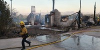 Firefighters clean up as the Edgehill Fire destroyed several homes and vehicles in San Bernardino, Calif., Aug. 5, 2024. 