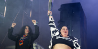 French DJ Barbara Butch (R) holds the paralympic flame flanked by French-Iranian writer Marjane Satrapi during the 20th edition of the Rock en Seine music festival, in Saint-Cloud, outside Paris, on August 25, 2024. 