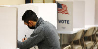 A voter fills out his ballot in a polling station at San Francisco City Hall in 2022.