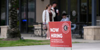 A Now Hiring sign advertising job openings outside of a Chipotle Mexican Grill restaurant, in Windermere, Fla., on March 18, 2024. 