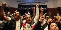 Demonstrators raise their fists after entering the Senate building as a highly contested judicial reform proposal is debated, following its approval by the Chamber of Deputies and backing by senators at the commission stage, in Mexico City