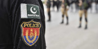 A detail view of a Pakistan flag patch and a Pakistan police patch on the arm of an officer's uniform