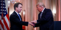 Brett Kavanaugh shakes hands with Donald Trump.