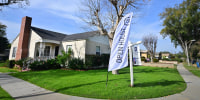 An "Open House" flag in front of a house for sale