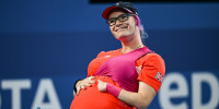 Jodie Grinham holds her pregnancy bump.