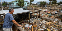 A man looks at debris 