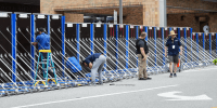 An AquaFence flood wall is put into place by workers outside of a hospital