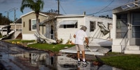 A resident cleans the front of his mobile home after Hurricane Milton's landfall