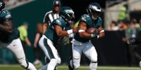 Jalen Hurts hands the ball to Saquon Barkley