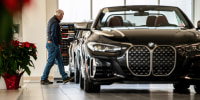 A customer looks at a vehicle at a BMW dealership