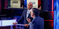 Colin Allred listens as Ted Cruz speaks