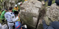 A woman was rescued after being wedged upside down between boulders for 7 hours, in Australia.