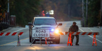 A law enforcement official moves a road block into place near Schemengees Bar on Oct. 26, 2023, the day after a mass shooting in Lewiston, Maine.