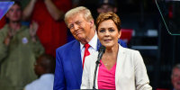 Republican Senate candidate Kari Lake speaks in front of former President Donald Trump in Prescott Valley, Ariz., on Oct. 13, 2024.
