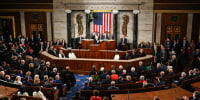 House members seated inside of the House Chamber room, Joe Biden speaks at the podium in the center