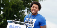 Trevon Bosley speaks onstage behind a podium with a sign that says "March for Our Lives"