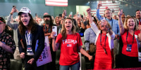 Supporters cheer in a large crows wearing Trump hats and shirts