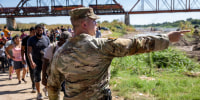 A Texas National Guard soldier directs immigrants