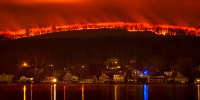 A night time view of the Jennings Creek wildfire burning behind homes in Greenwood Lake, N.Y.