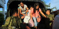 Hundreds of people fled on November 15 as Typhoon Man-Yi bore down on the Philippines, threatening yet more destruction even as rescuers tried to reach people stranded on rooftops by the last tropical cyclone.