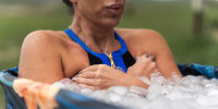 Female athlete taking ice bath for recovery after hard training session