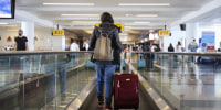 A traveler walks on a moving walkway.