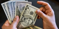 A person holds U.S. dollar bills in his hand on Sept. 6, 2023.