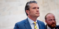 Pete Hegseth and his wife, Jennifer Rauchet, walk through the Russell Senate Office building on Capitol Hill on Dec. 3, 2024.