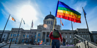 A person carries a pride flag at Montana State Capitol.