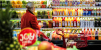 Fruit is displayed as a woman shops in a supermarket