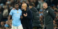 Manchester City's head coach Pep Guardiola talks to Jeremy Doku 