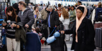 Travelers check in at O'Hare International Airport in Chicago.