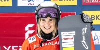 Sophie Hediger smiles and holds her snowboard outside