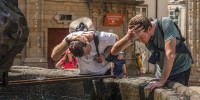 Visitors refresh themselves with water from a fountain.